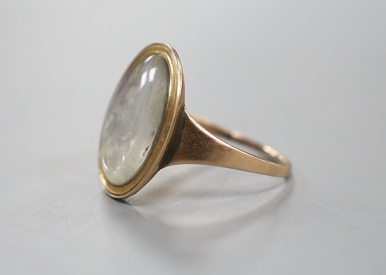 An early 19th century yellow metal ring inset with ivory? panel of a young lady